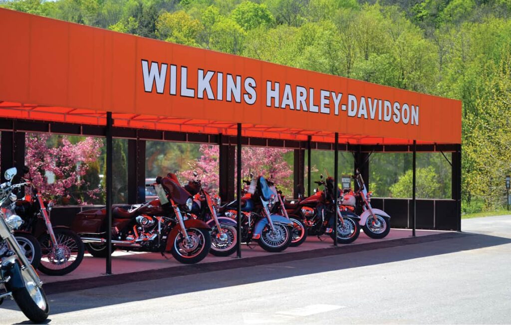 Orange awning for Wilkins Harley Davidson with motorcycles in front.