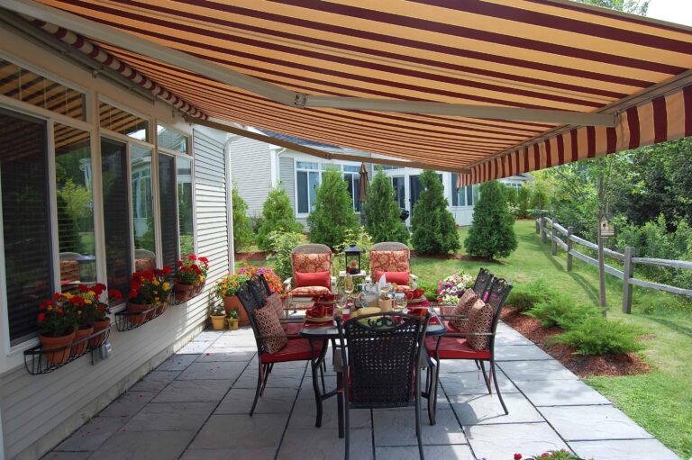 Striped retractable awning over patio with outdoor dining table.