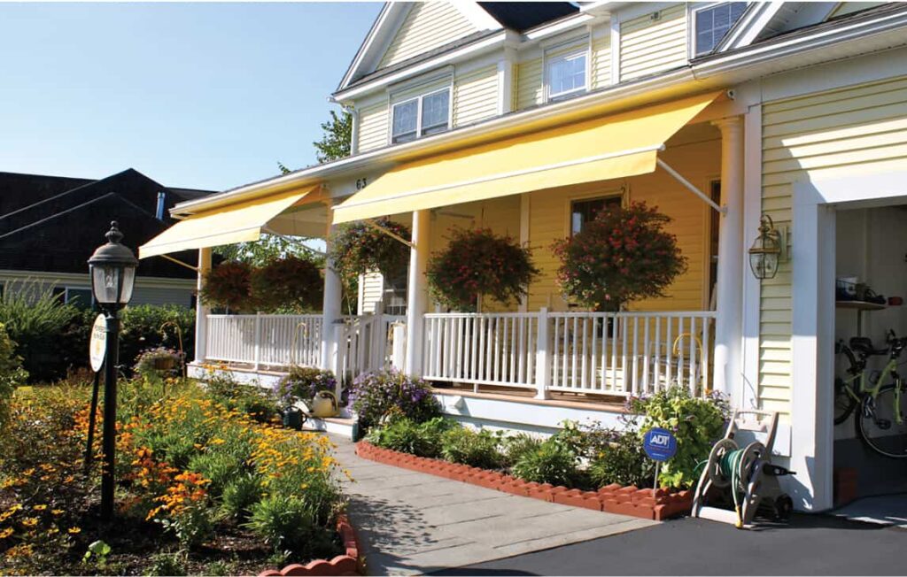 Yellow window awnings with hanging baskets