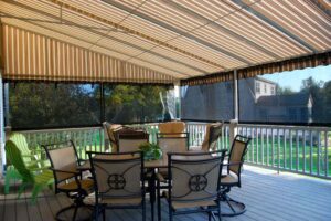 View sitting under deck canopy with a table and chairs and drop curtains.