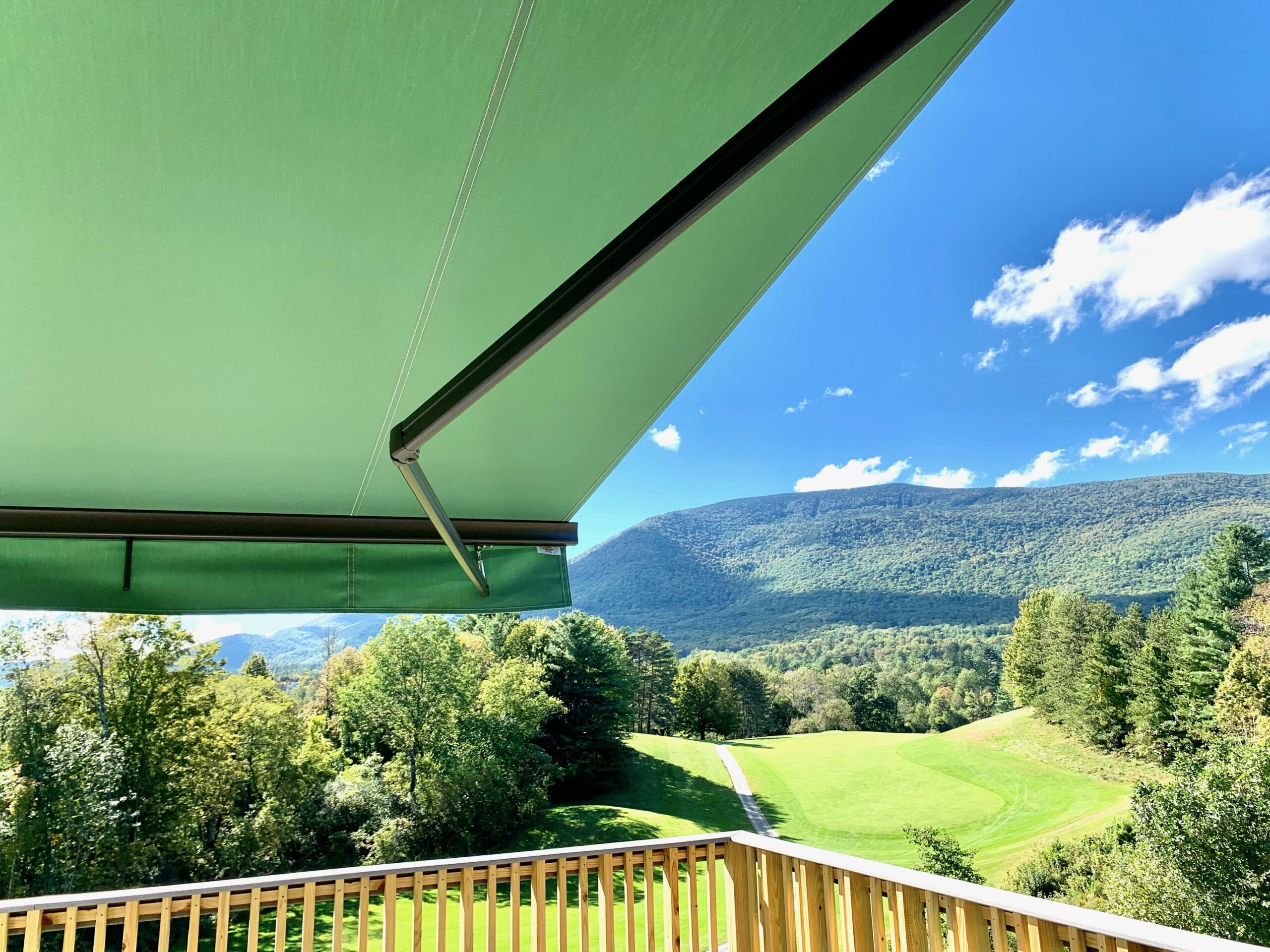 Green retractable awning overlooking the green mountains
