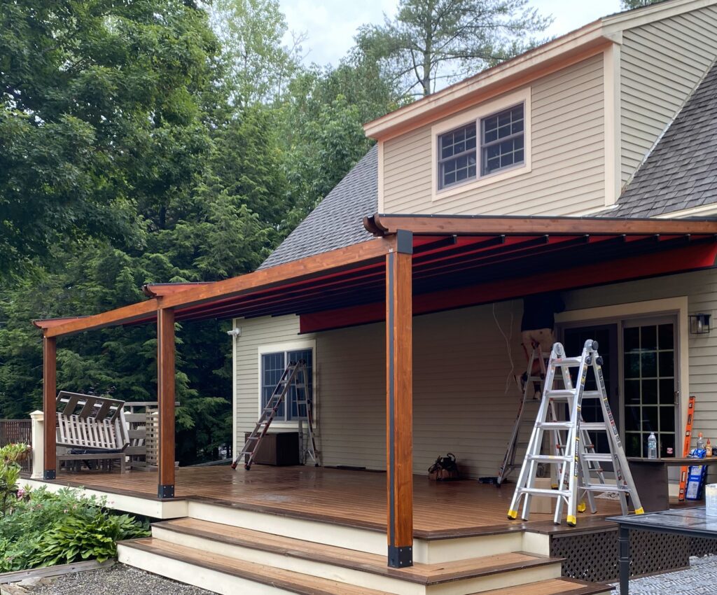 Stained wood wrapped posts on tan house with expansive deck.